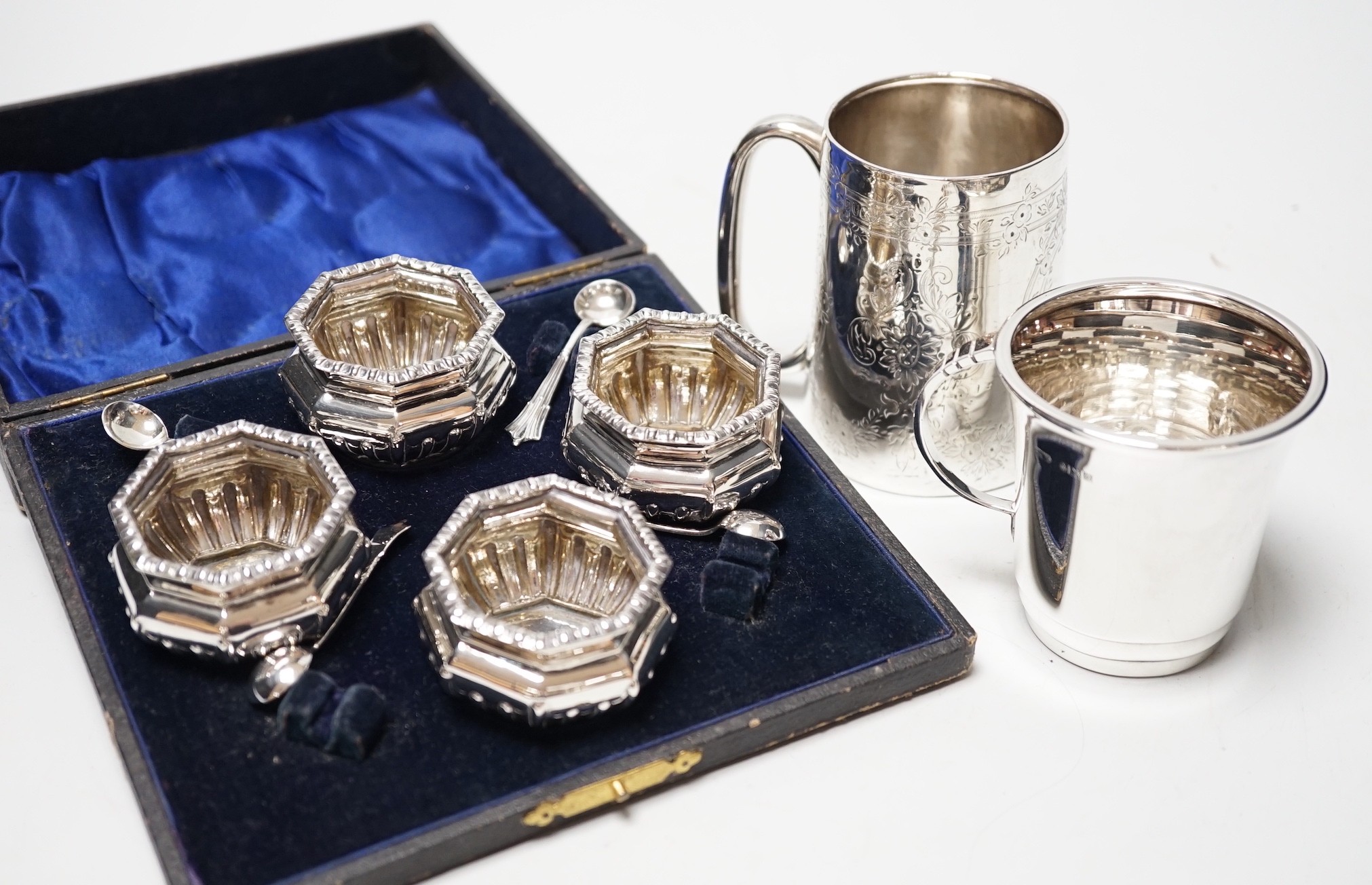A late Victorian engraved silver christening cup, a later silver christening cup and a cased set of silver salts.
